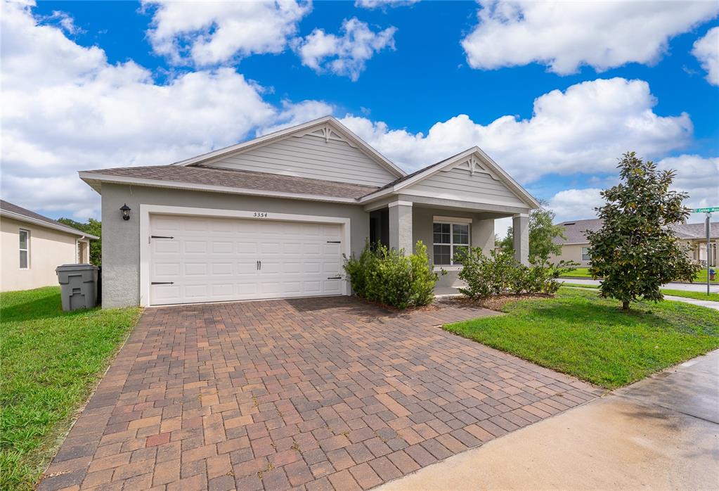 A single-story house with a paved driveway, two-car garage, and a covered front porch — 5354 PALOMINO PLACE, APOPKA, FL