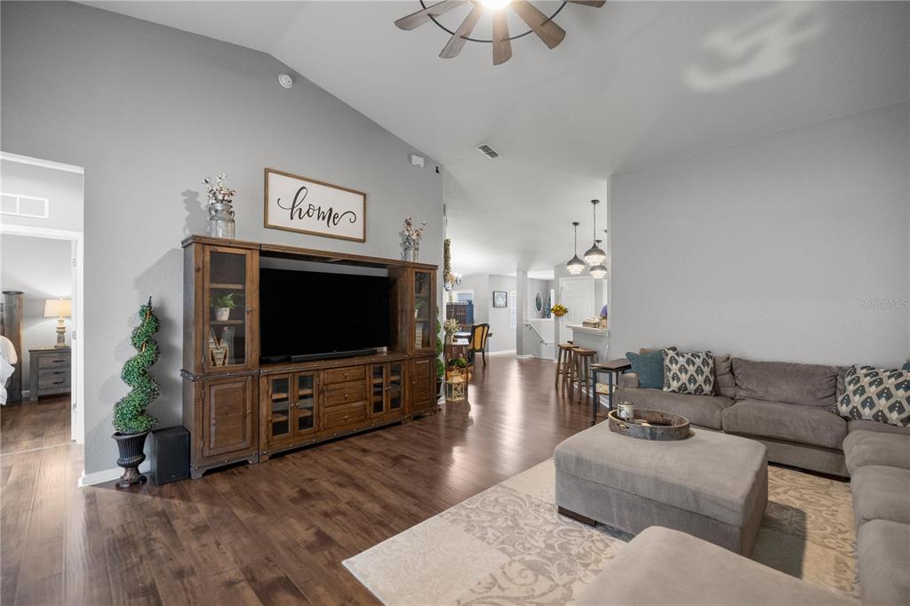 A living room features a large wooden entertainment center, gray walls, and dark hardwood floors — 4525 SW 52ND CIRCLE UNIT 106, OCALA, FL