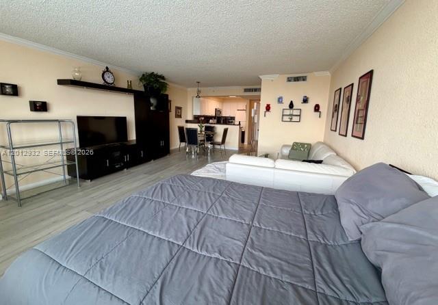 A bedroom with a grey bed, white sofa, and television console in an open living area — 2501 S Ocean Dr # 1627, Hollywood FL 33019, HOLLYWOOD, FL