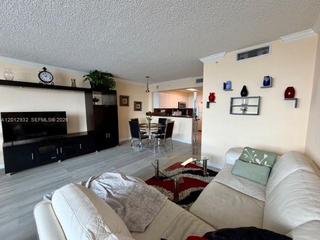 A living room features light wood-look flooring, a white sofa, and an open dining area — 2501 S Ocean Dr # 1627, Hollywood FL 33019, HOLLYWOOD, FL