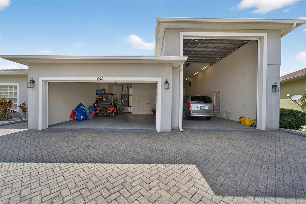 A single-story house features a paved driveway, a two-car garage, and a large palm tree — 453 NOLANE LANE, POLK CITY, FL