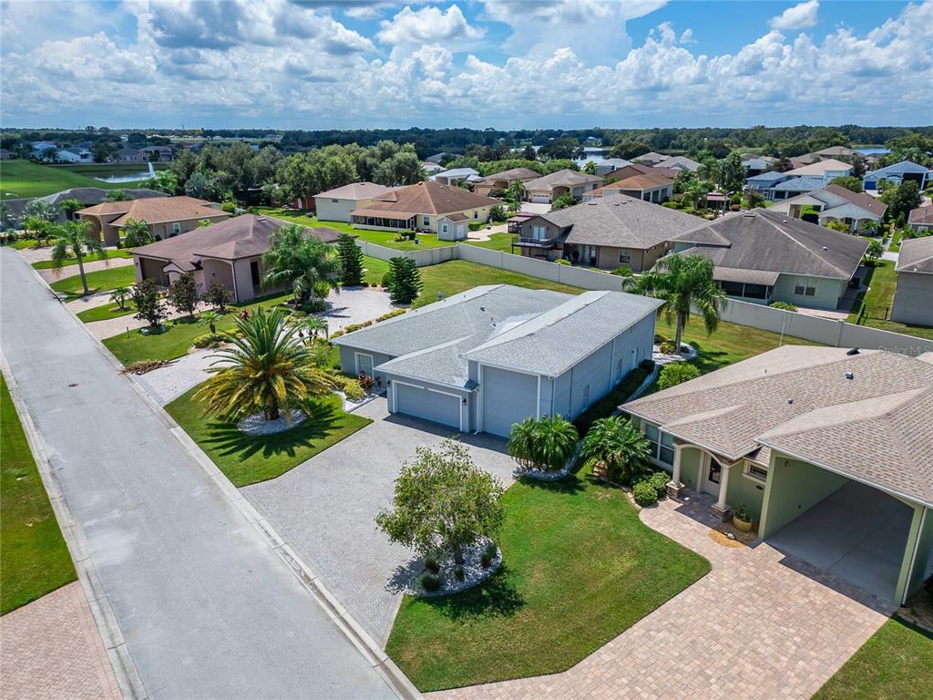 A paved walkway leads to the arched entryway of a light-colored stucco home — 453 NOLANE LANE, POLK CITY, FL