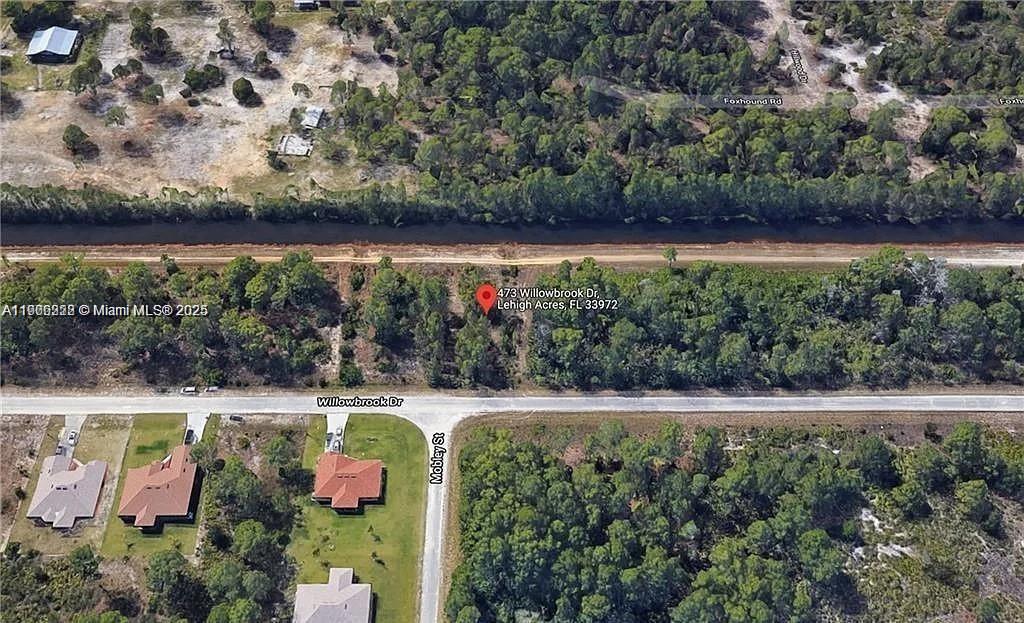 This is an aerial map view of a vacant, wooded residential lot — 473 Willowbrook Dr, Lehigh Acres FL 33972, LEHIGH ACRES, FL