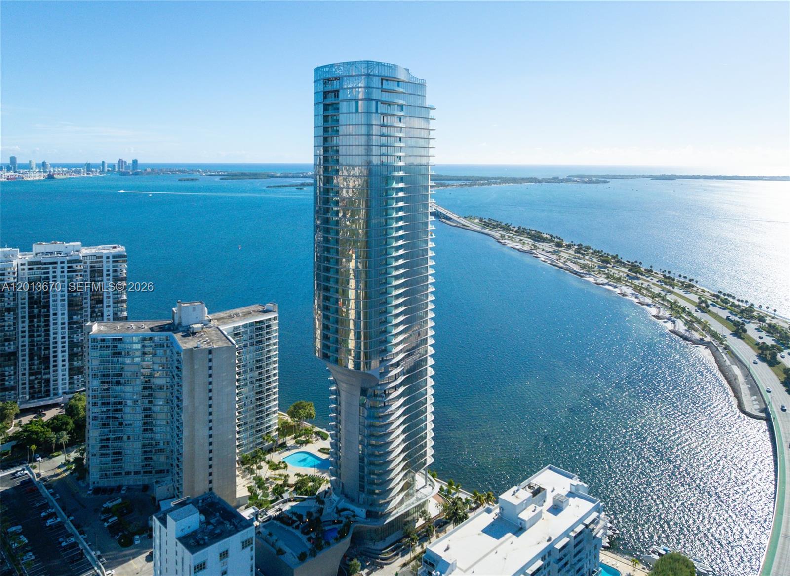 An aerial view shows a modern glass skyscraper rising above a waterfront in Miami — 175 SE 25th Rd # 4202, Miami FL 33129, MIAMI, FL
