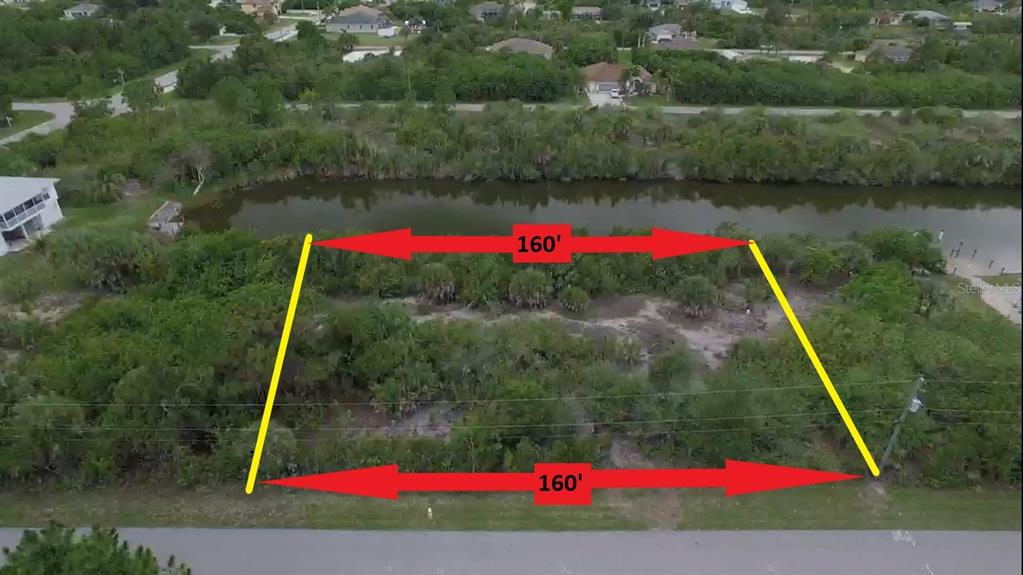 An aerial view shows a vacant, rectangular lot with 160-foot frontage bordering a small canal — 15536 & 15544 HENNIPEN CIRCLE, PORT CHARLOTTE, FL