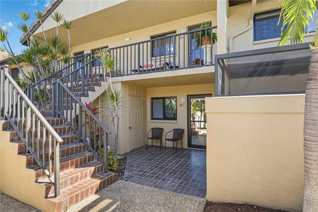 A two-story building exterior features a tiled staircase leading to an upper balcony and patio — 5515 ASHTON WAY UNIT 5515, SARASOTA, FL