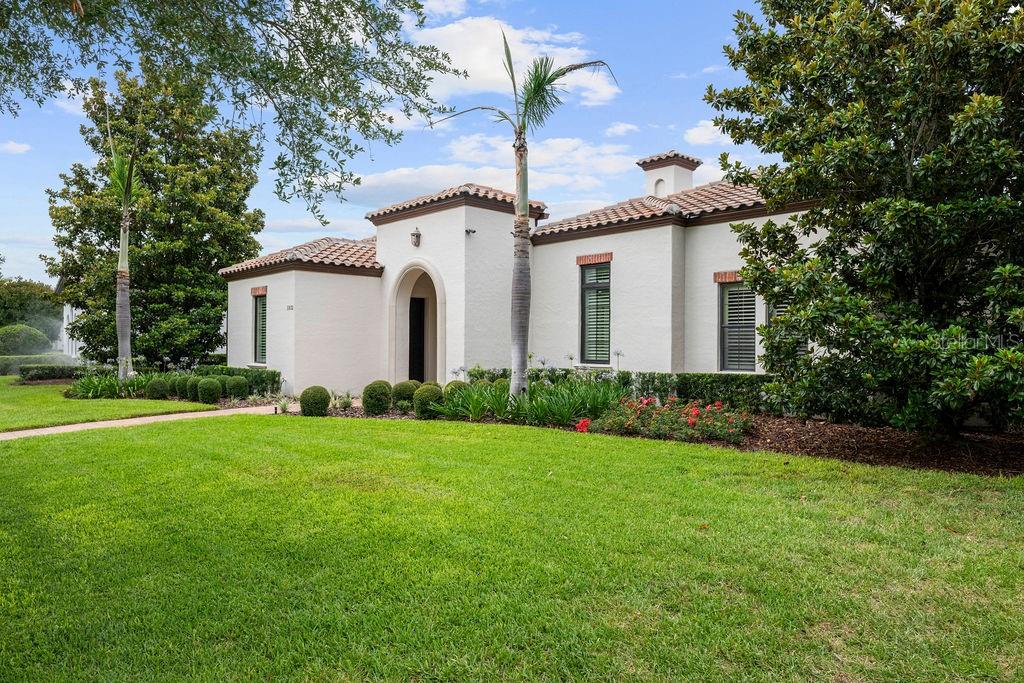 A single-story Mediterranean-style house with a stucco exterior, tile roof, and a manicured lawn — 11832 WATERSTONE LOOP DRIVE, WINDERMERE, FL