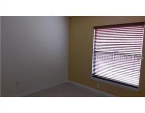 A bedroom with beige carpet, a white wall, a yellow wall, and a window with blinds — 13109 ELGAR PLACE, RIVERVIEW, FL