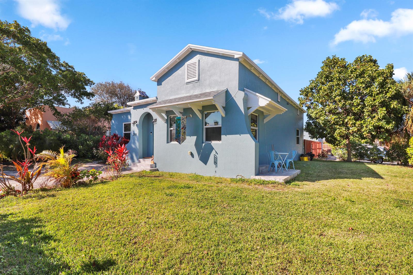 A light blue single-story house with a front porch and a grassy yard — 301 Hawthorne Drive, Lake Park FL 33403, LAKE PARK, FL