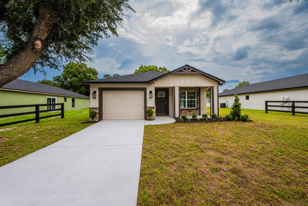 A single-story house with a beige exterior, a one-car garage, and a front porch — 4570 WINDEE AVENUE, LAKELAND, FL