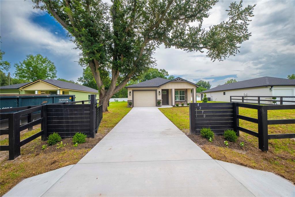 A single-story house with a concrete driveway and black wooden fencing in the front yard — 4570 WINDEE AVENUE, LAKELAND, FL