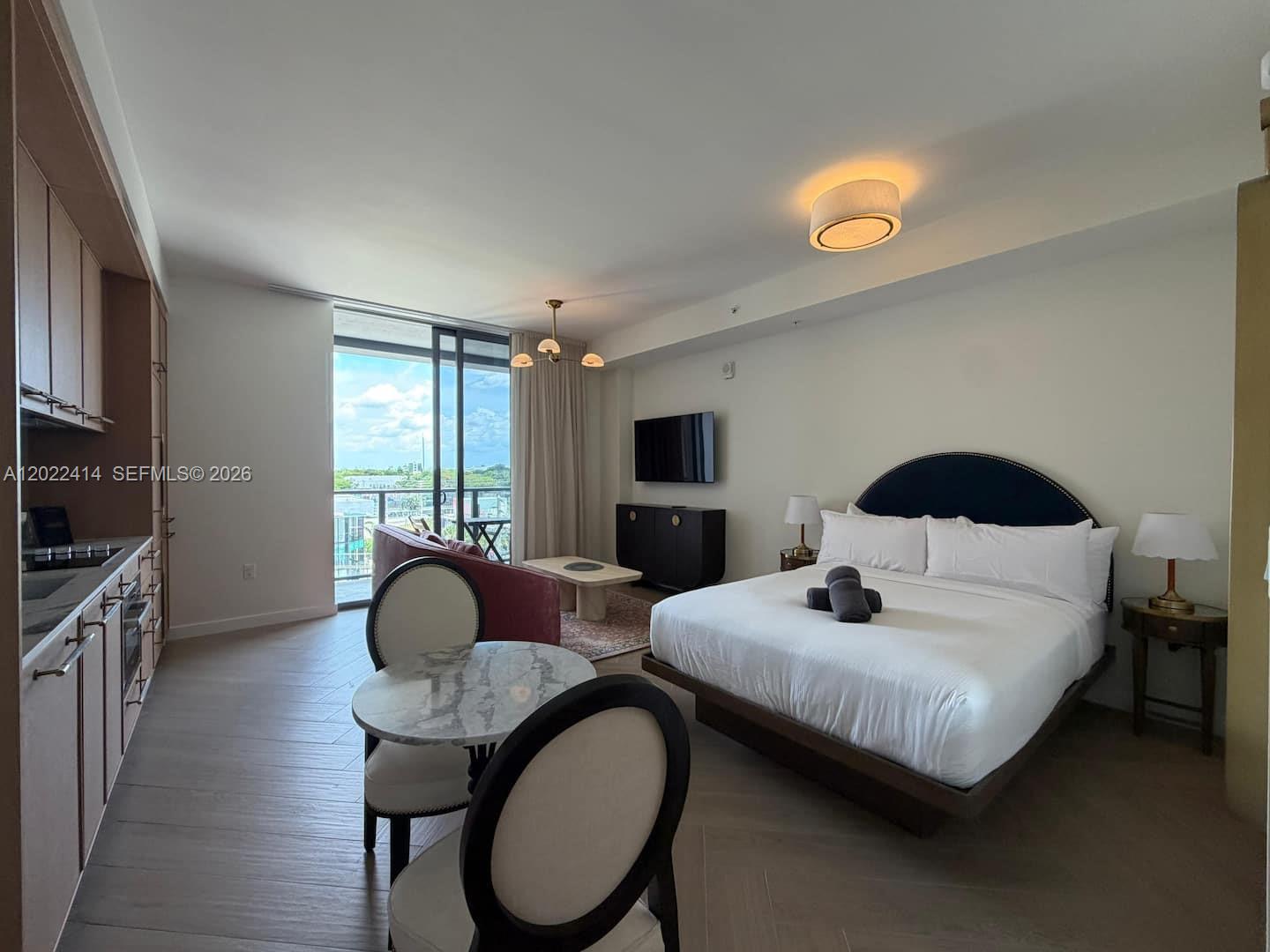 A studio apartment features a kitchenette, a dining table, a bed, and a balcony view — 2700 NW 2nd Ave # 424, Miami FL 33127, MIAMI, FL