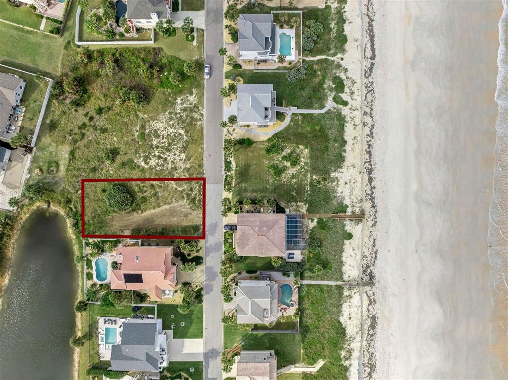 This aerial view shows a vacant residential lot outlined in red next to a road — 22 OCEAN DUNE CIRCLE, PALM COAST, FL