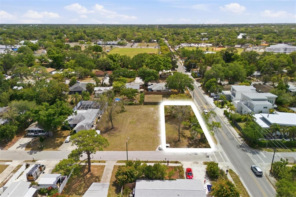 An aerial view shows a vacant, rectangular residential lot highlighted in white next to a road — 0 BAY STREET, SARASOTA, FL