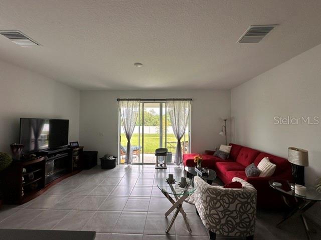 A living room features tile flooring, a red sectional sofa, and a sliding glass door — 388 MANGROVE SHADE CIRCLE, APOLLO BEACH, FL
