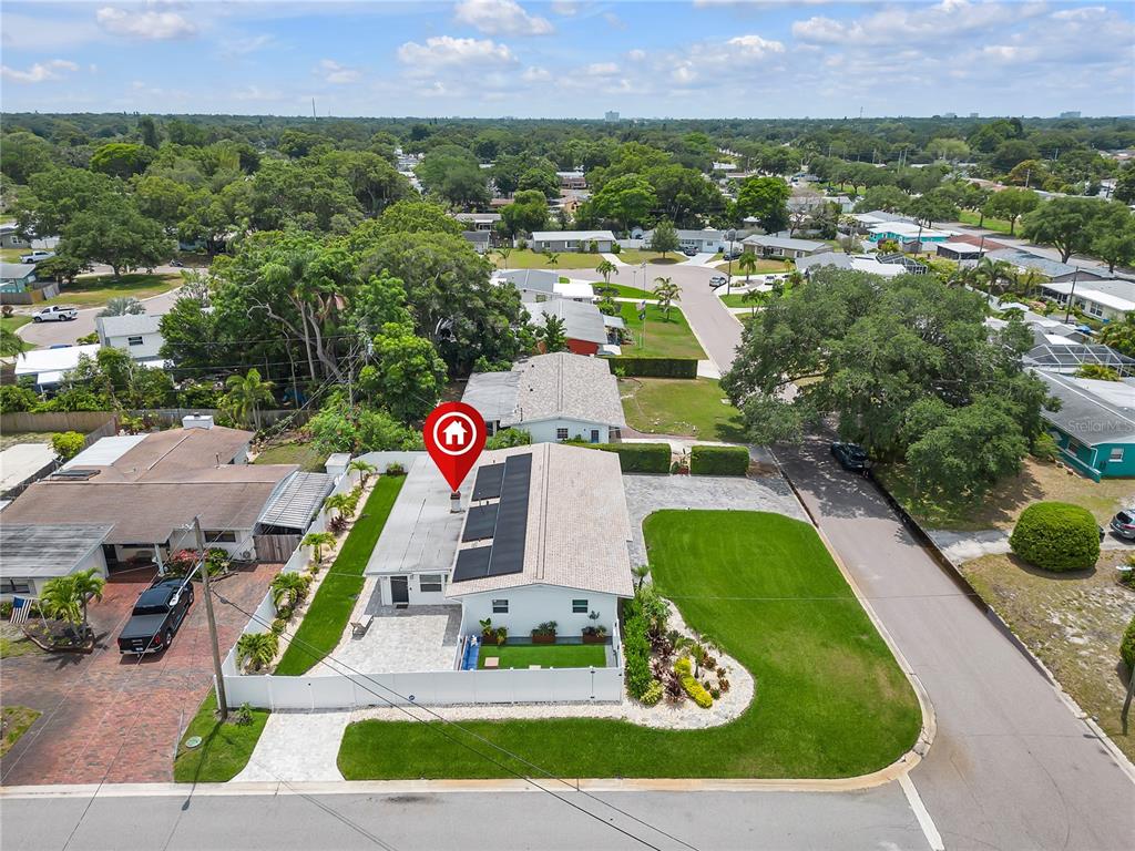 An aerial view shows a single-story house with solar panels and a fenced yard — 3295 57TH STREET N, ST PETERSBURG, FL
