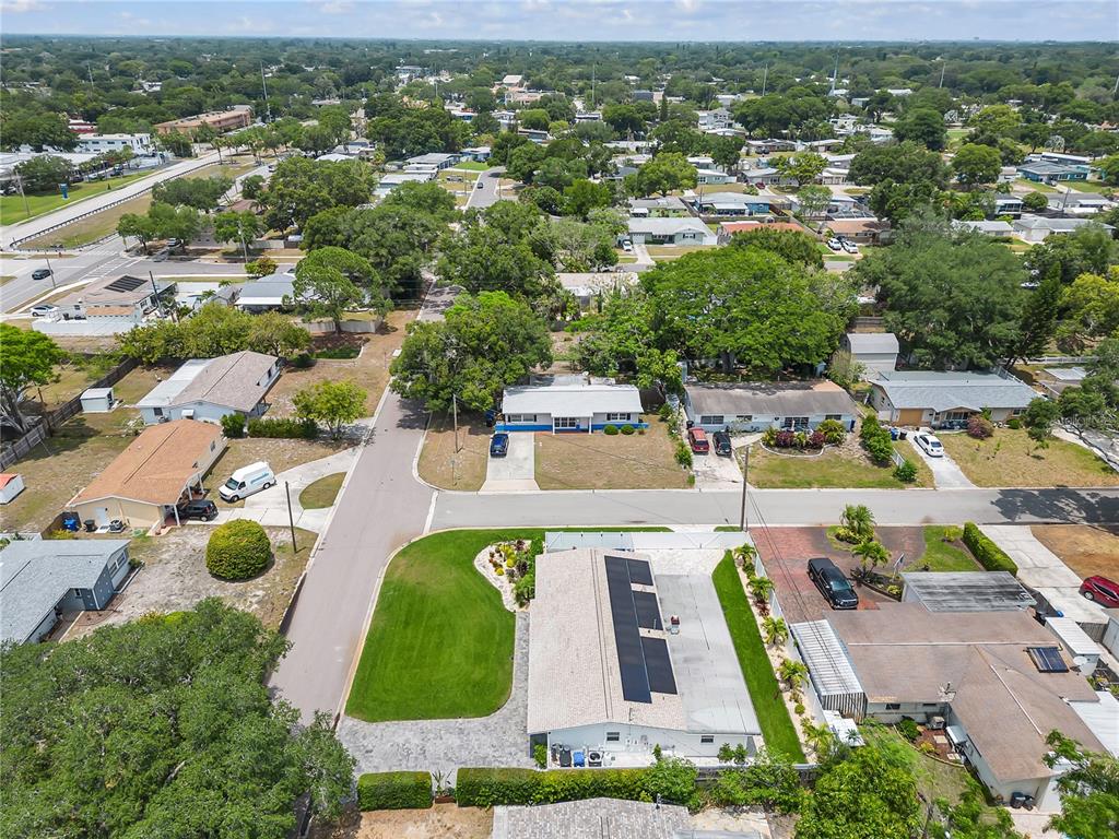 An aerial view shows a residential neighborhood with houses, driveways, and surrounding trees — 3295 57TH STREET N, ST PETERSBURG, FL