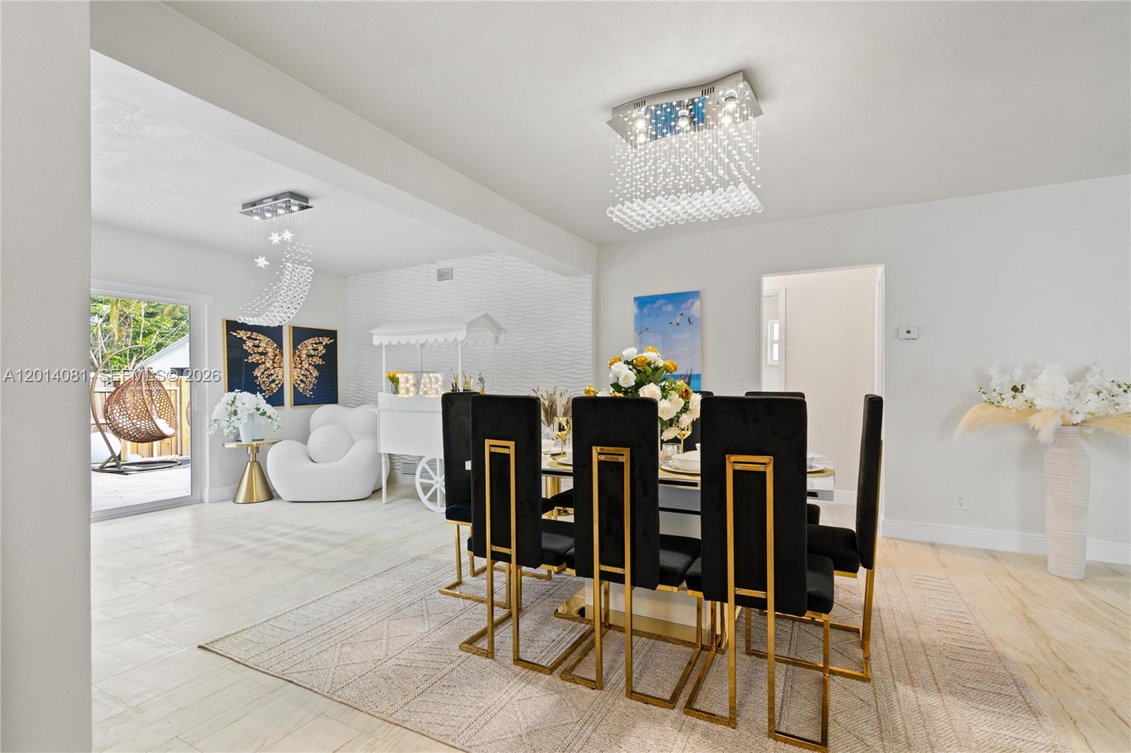 A dining room features a modern crystal chandelier, black and gold chairs, and a bar cart — 2125 N 14th Ct, Hollywood FL 33020, HOLLYWOOD, FL