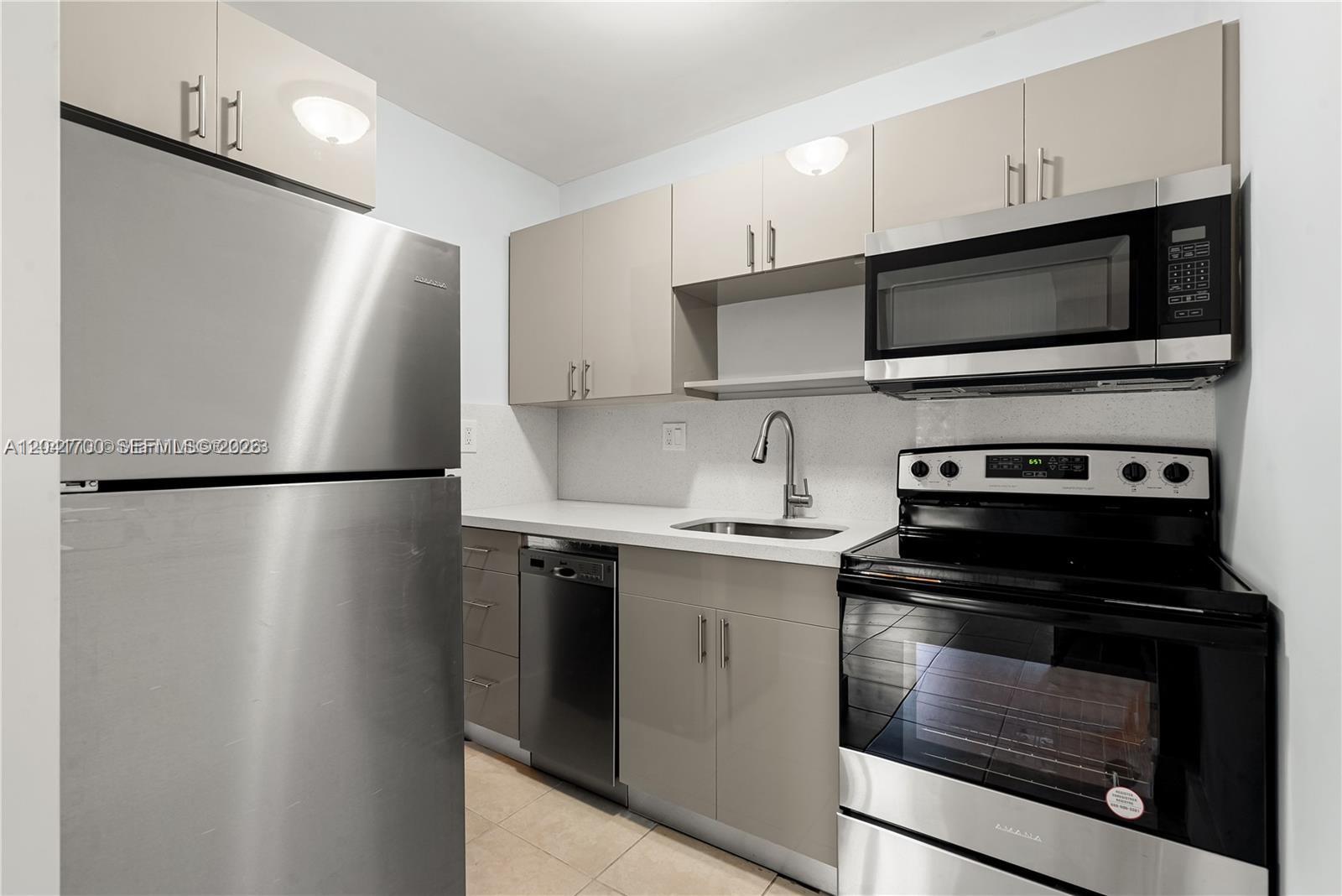 A small kitchen features stainless steel appliances, light-colored cabinets, and a white countertop — 7722 NE 3rd Ct # 2, Miami FL 33138, MIAMI, FL