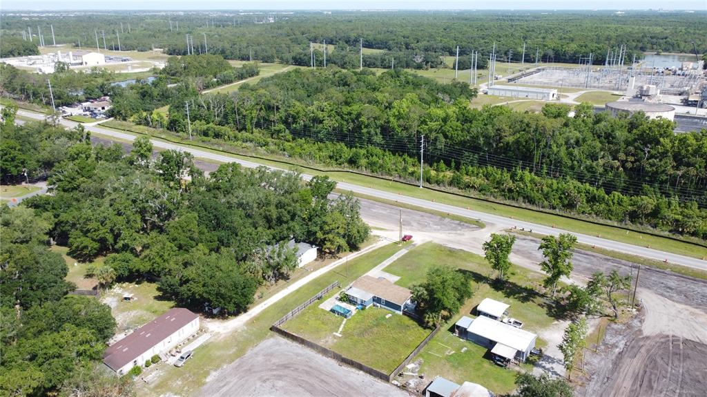An aerial view shows several houses, a road, and a large electrical substation nearby — 6590 OSCEOLA POLK LINE ROAD, DAVENPORT, FL