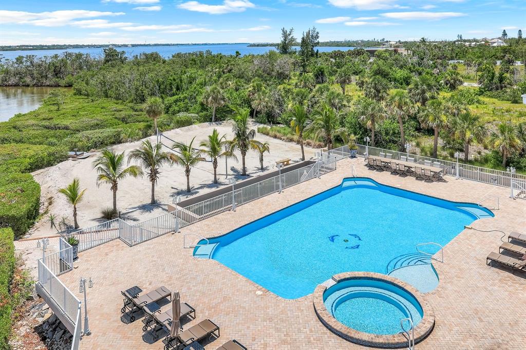 An aerial view of a swimming pool, hot tub, and sand volleyball court near water — 7159 MANASOTA KEY ROAD, ENGLEWOOD, FL