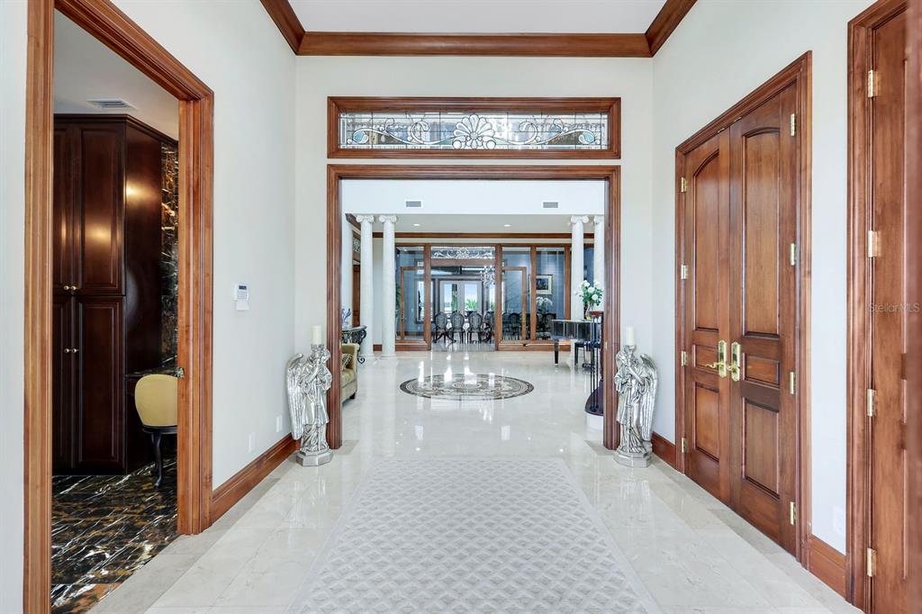 A marble-floored foyer features wood trim, double doors, and a view into a large room — 7159 MANASOTA KEY ROAD, ENGLEWOOD, FL
