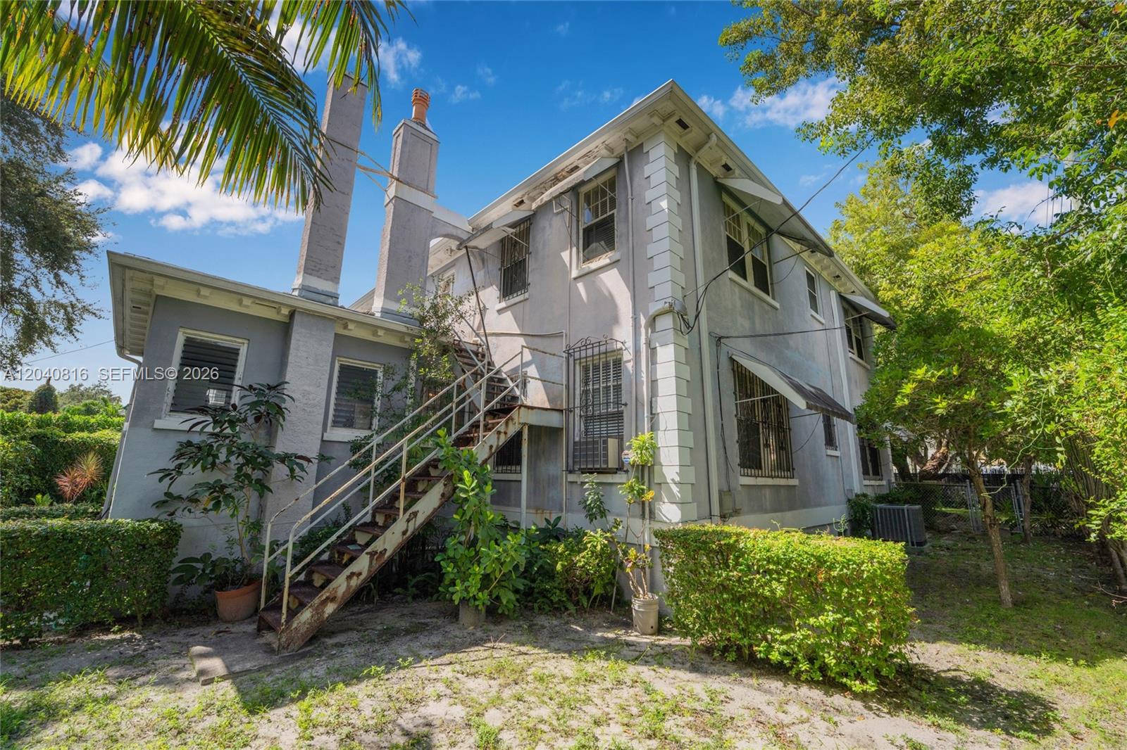An exterior view of a two-story gray house with an external metal staircase — 405 SW 11th Ave, Miami FL 33130, MIAMI, FL