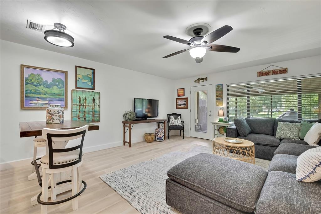 A living room features light wood flooring, a grey sectional sofa, and a dining area — 1637 SE PARADISE CIRCLE UNIT 106, CRYSTAL RIVER, FL