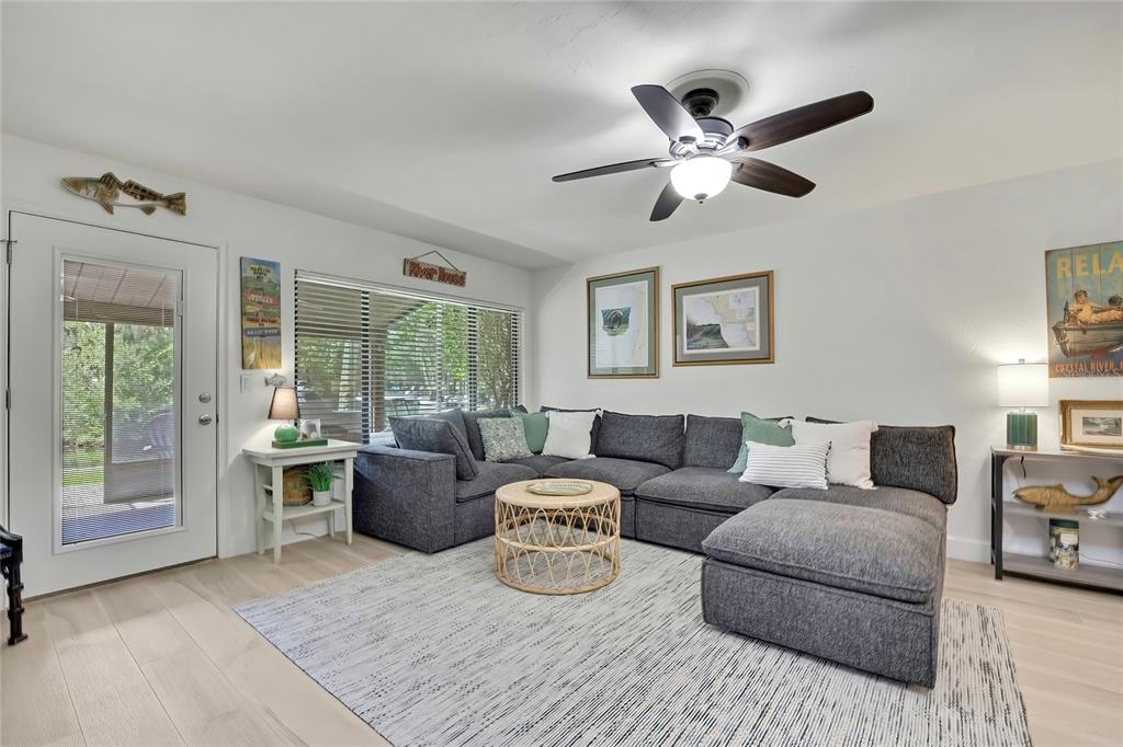 A living room features a gray sectional sofa, a round coffee table, and a ceiling fan — 1637 SE PARADISE CIRCLE UNIT 106, CRYSTAL RIVER, FL