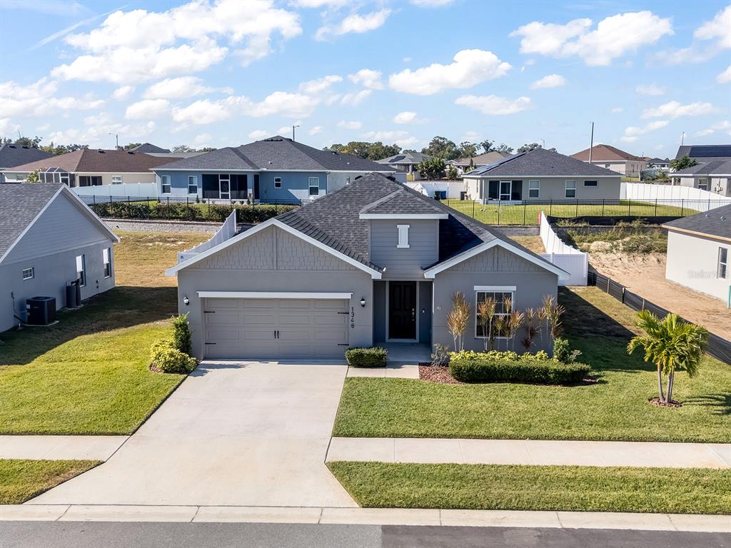 A single-story gray house with a two-car garage and a front lawn under a blue sky — 1348 MELROSE STREET, LAKE ALFRED, FL