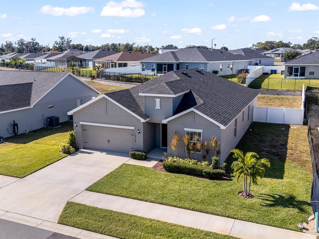 An aerial view of a gray single-story suburban house with a dark shingled roof — 1348 MELROSE STREET, LAKE ALFRED, FL