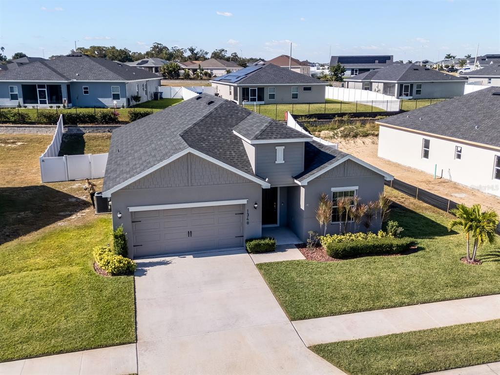 An aerial view of a gray single-story suburban house with a two-car garage — 1348 MELROSE STREET, LAKE ALFRED, FL