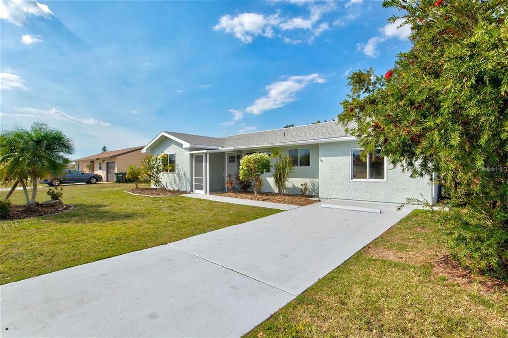 A light green single-story house with a concrete driveway and a front yard — 6792 HIGDON ROAD, NORTH PORT, FL