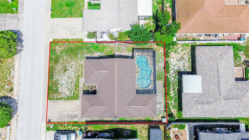 An aerial view shows a house with a screened-in pool on a fenced residential lot — 8234 WINTHROP DRIVE, PORT RICHEY, FL
