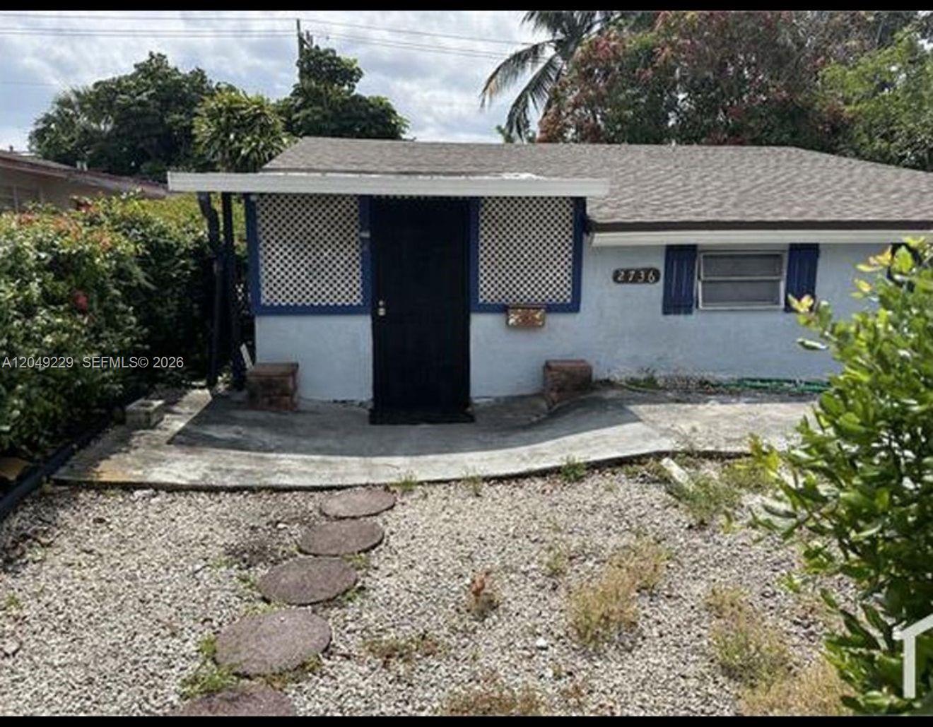 A single-story house with a gravel front yard, a concrete walkway, and a black door — 2736 NW 2nd St # 2736, Pompano Beach FL 33069, POMPANO BEACH, FL