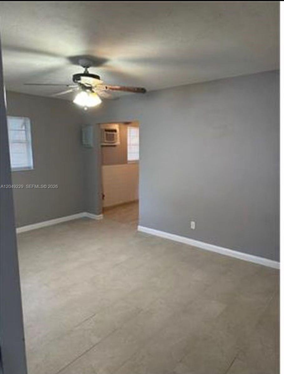 An empty room with gray walls, light tile flooring, and a ceiling fan — 2736 NW 2nd St # 2736, Pompano Beach FL 33069, POMPANO BEACH, FL