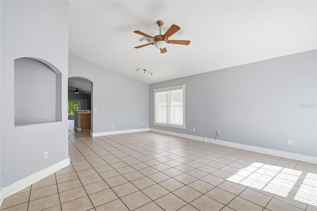 A spacious living room features light gray walls, tile flooring, and a ceiling fan — 632 CYPRESS TREE COURT, ORLANDO, FL