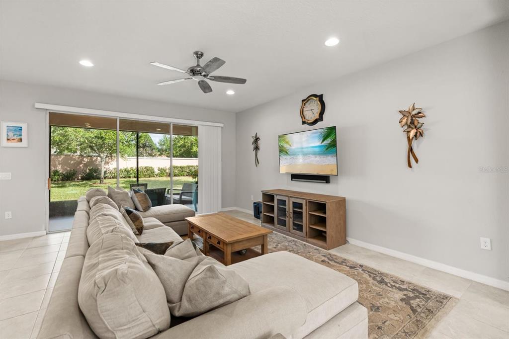 A living room features a large sectional sofa, a wooden coffee table, and a television — 1483 EL CONTE DRIVE, DAVENPORT, FL