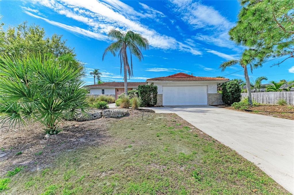 A single-story house with a white garage, a tile roof, and palm trees in front — 507 GULF STREET, VENICE, FL