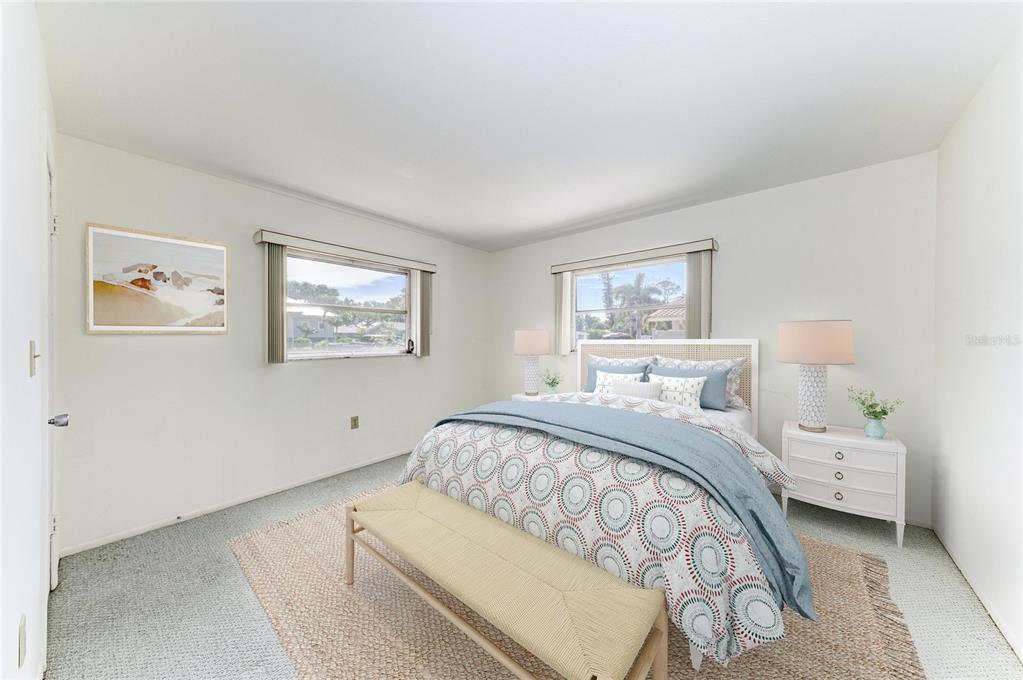 A bedroom features a bed with patterned bedding, a bench, and two windows — 507 GULF STREET, VENICE, FL