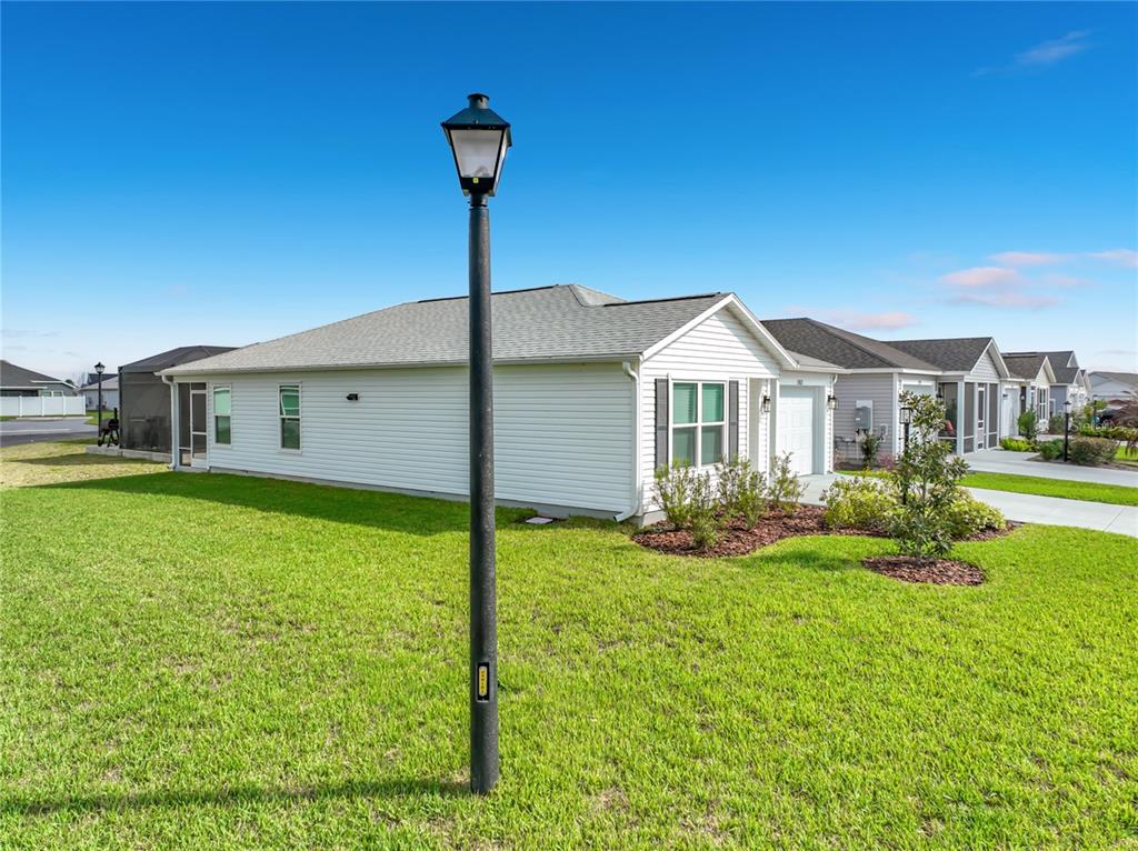 A white, single-story suburban house with a lamp post in the foreground — 1763 BRODY COURT, THE VILLAGES, FL