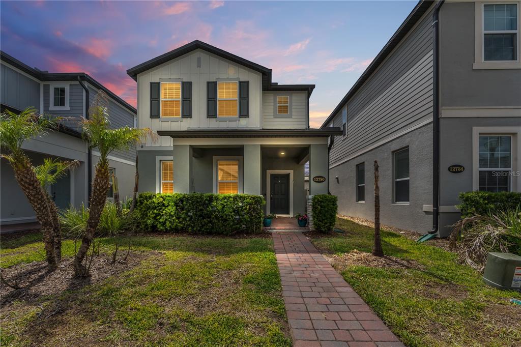 A two-story house with a brick walkway, front porch, and manicured hedges — 12790 BRODLOVE LANE, WINTER GARDEN, FL