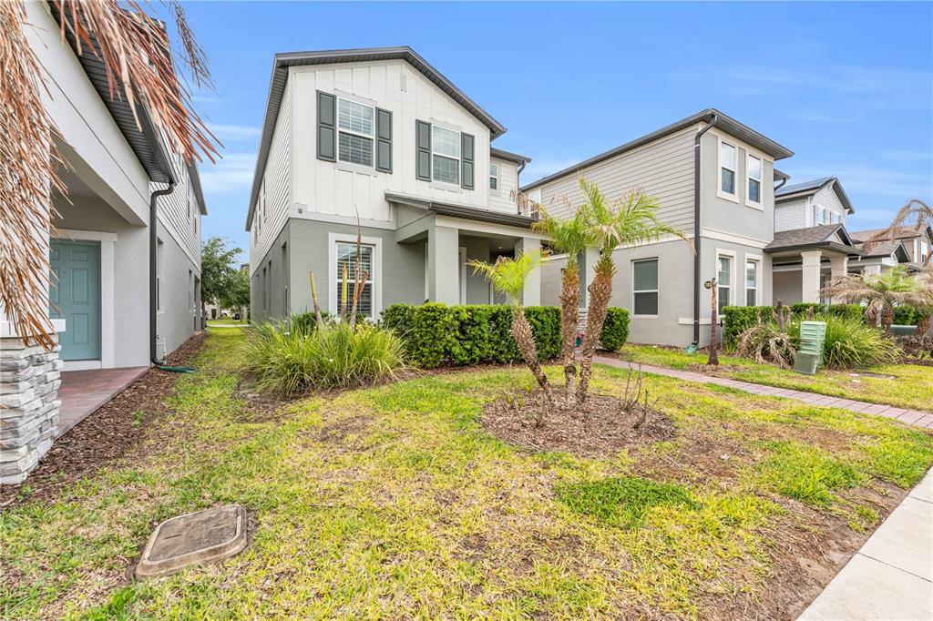 A two-story house with a covered porch, green landscaping, and a palm tree in front — 12790 BRODLOVE LANE, WINTER GARDEN, FL