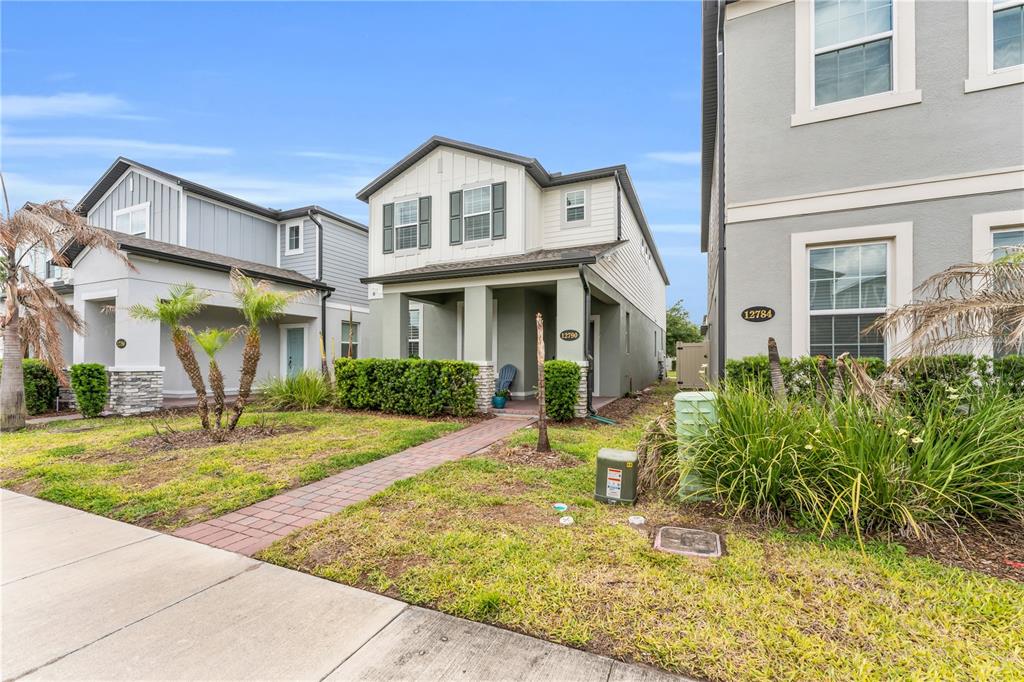 A two-story house with a covered front porch and a brick walkway — 12790 BRODLOVE LANE, WINTER GARDEN, FL