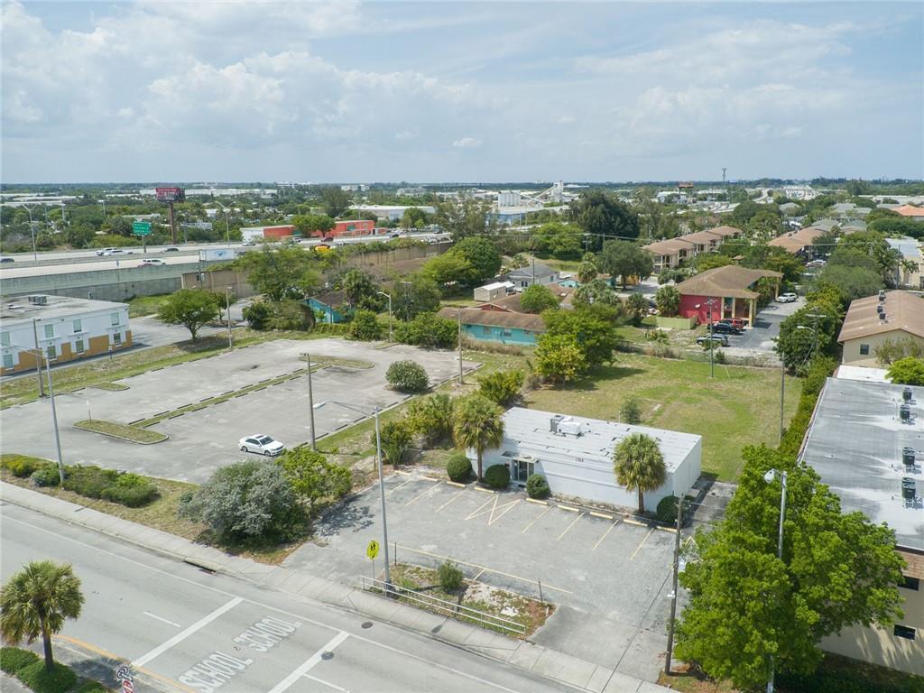 An aerial view shows a commercial building with a parking lot next to a highway — 1744 Lake Worth Road, FL 33460, FL