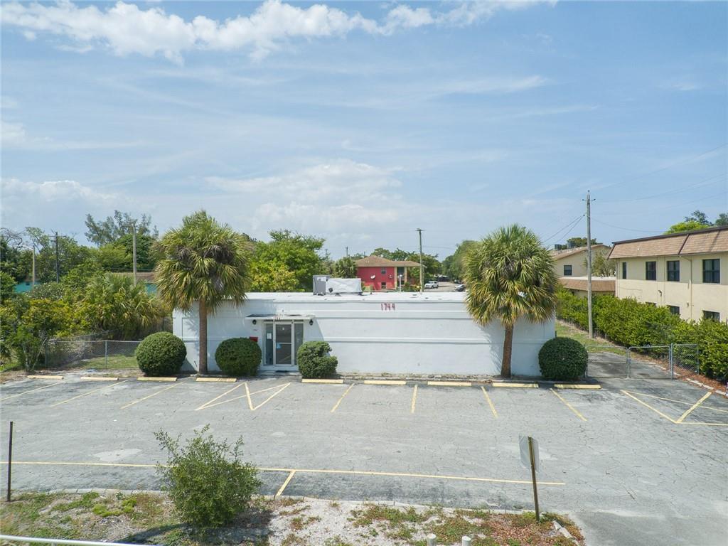 A one-story white commercial building features a front parking lot and two palm trees — 1744 Lake Worth Road, FL 33460, FL