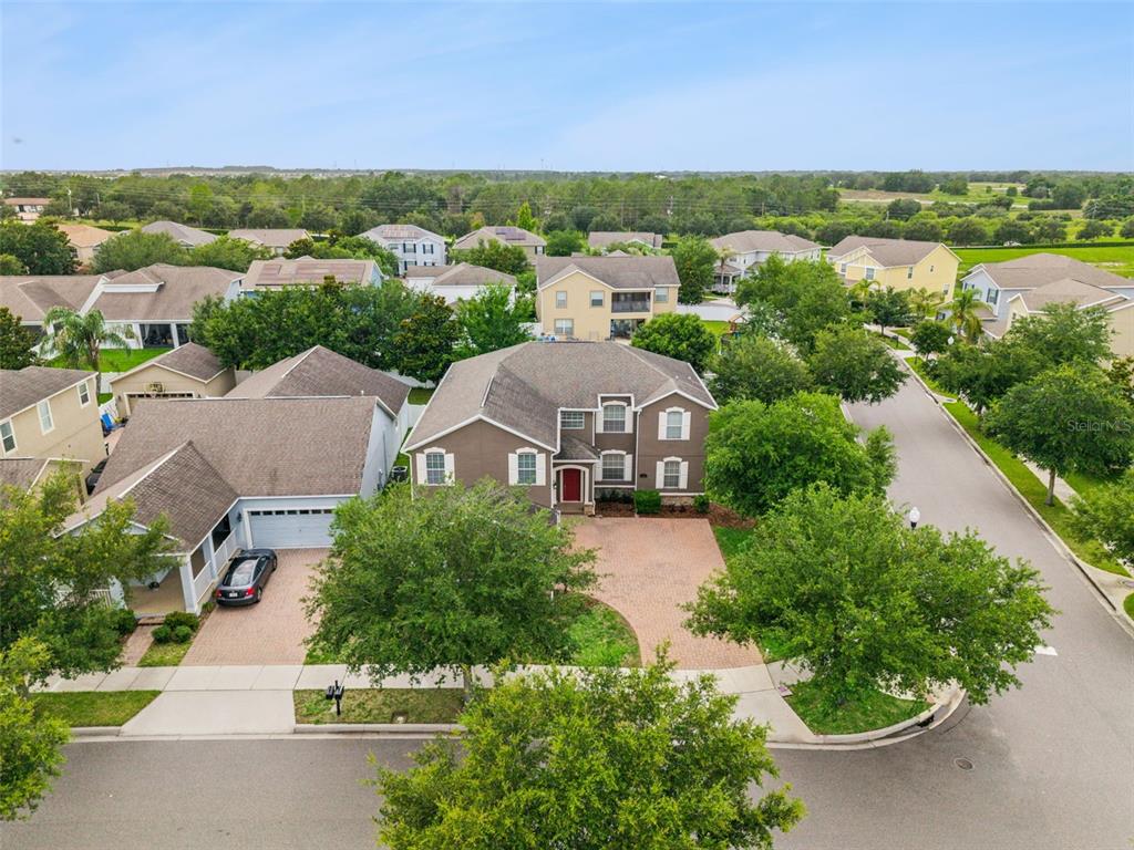 An aerial view shows a two-story suburban house with a brick driveway and surrounding trees — 6100 CYPRESS HILL ROAD, WINTER GARDEN, FL