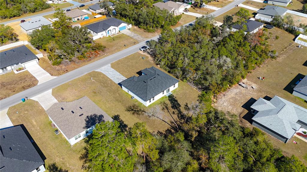 An aerial view shows several suburban houses with dark roofs surrounded by trees and lawns — 2632 SW 162ND STREET ROAD, OCALA, FL