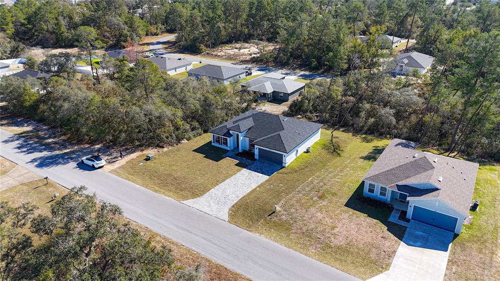 An aerial view shows two modern single-story houses with paved driveways on a suburban street — 2632 SW 162ND STREET ROAD, OCALA, FL