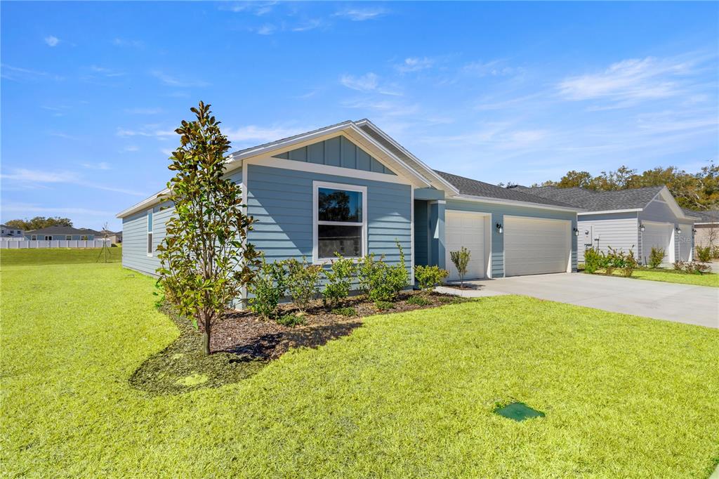 A blue, single-story suburban house with a two-car garage and a landscaped front yard — 8367 SW 41ST TERRACE, OCALA, FL